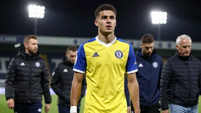 A 20-year-old anonymous Toulouse FC player, wearing a yellow and blue jersey with a white collar, walks around the...