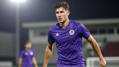 A young, athletic Toulouse Football Club player, 20-25 years old, with a muscular build, wearing a clean, solid purple...