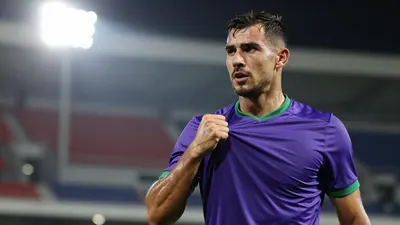 Mid-30s muscular forward, head turned toward a distant floodlight, sweat glistening on his brow, eyes sharp, lips...