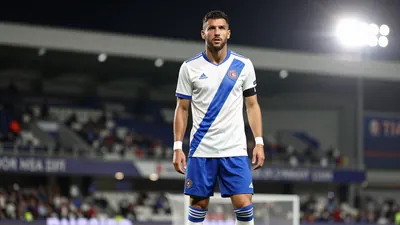 A photorealistic image of a Toulouse Football Club player in a white jersey with a blue stripe, wearing a blue pair of...