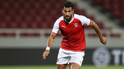 A tight action crop of an anonymous Toulouse Football Club player, aged 25-30, in a midfielder role, wearing a red jersey...