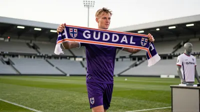 Tobias Guddal, wearing Toulouse's violet kit, bursts into frame, warm natural light, as he controls the ball on lush...