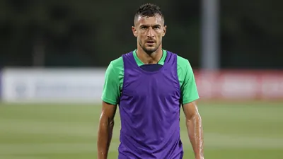 Mid-30s muscular Toulouse player, waist-up, sweat-glazed skin, intense eyes focused forward, wearing an unmarked training...