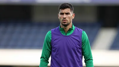 Mid-30s former forward, athletic build, waist-up, intense expression, short dark hair, slight stubble, eyes focused forward