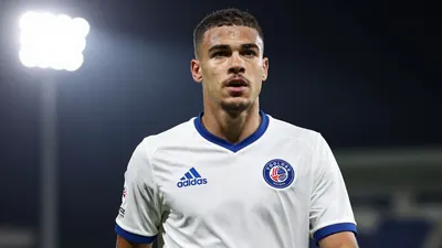 A photorealistic image of a 20-year-old Danish midfielder in a Toulouse Football Club jersey, with a white and blue kit...