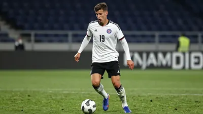 A photorealistic image of an anonymous 20-year-old German central defender in a Toulouse Football Club jersey, number 19...